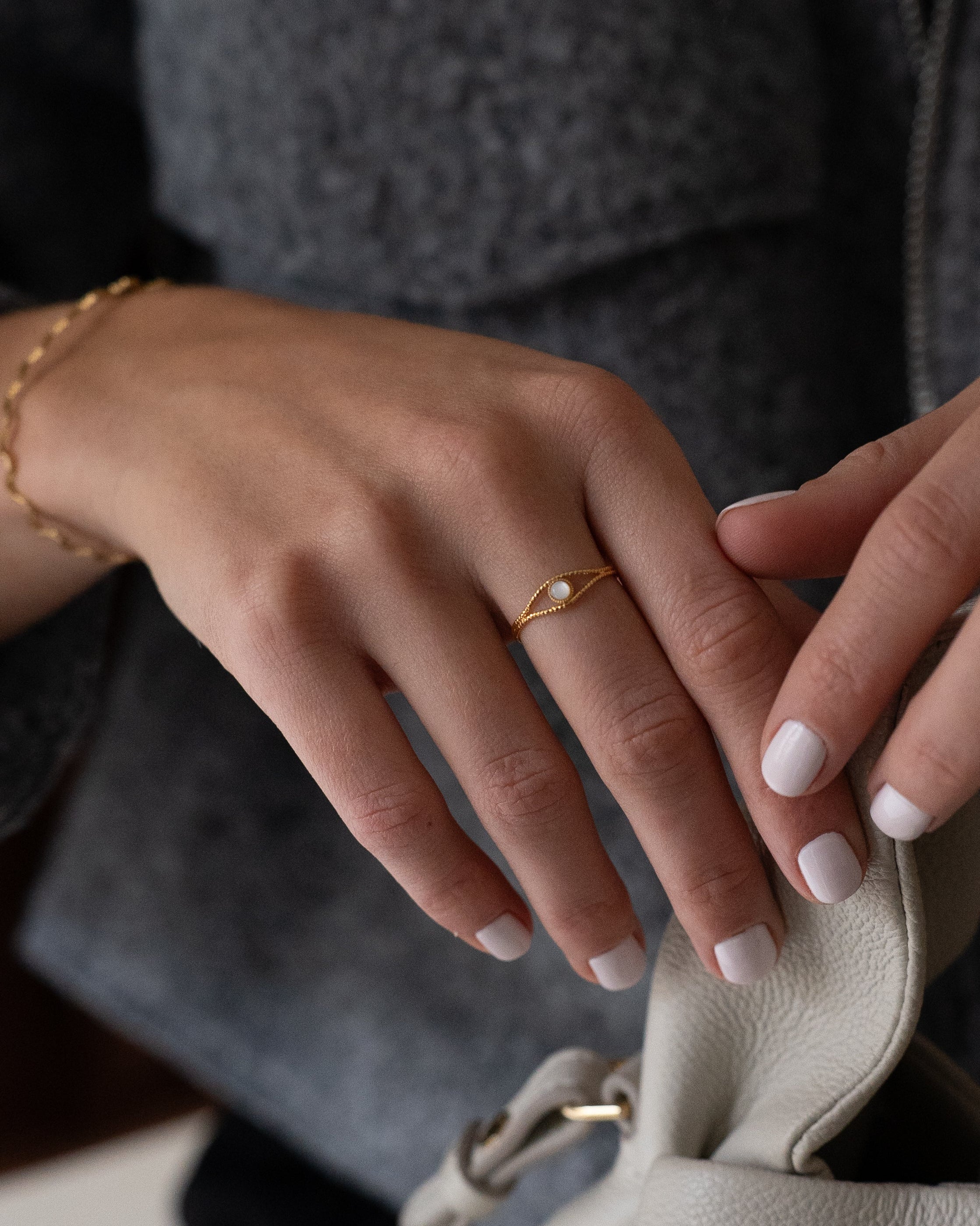 Bague en plaqué or ornée d’une nacre blanche, portée sur une main féminine élégante. Bijou minimaliste parfait pour un style sophistiqué et intemporel.