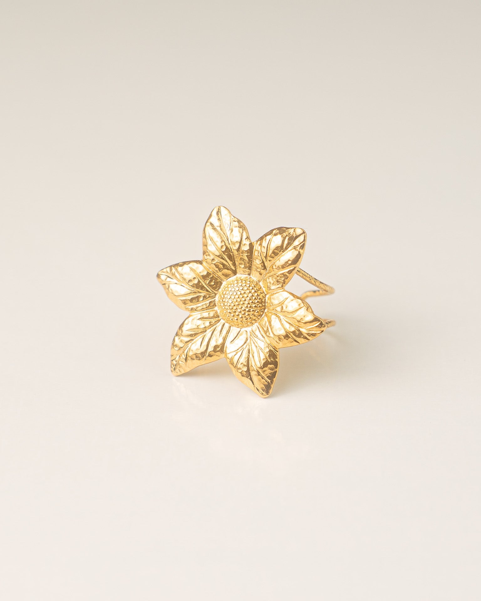 Bague en plaqué or en forme de fleur avec détails ciselés. Bijou chic et intemporel pour femme.